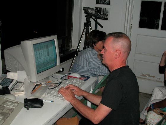 A person sitting at an old computer typing. 
